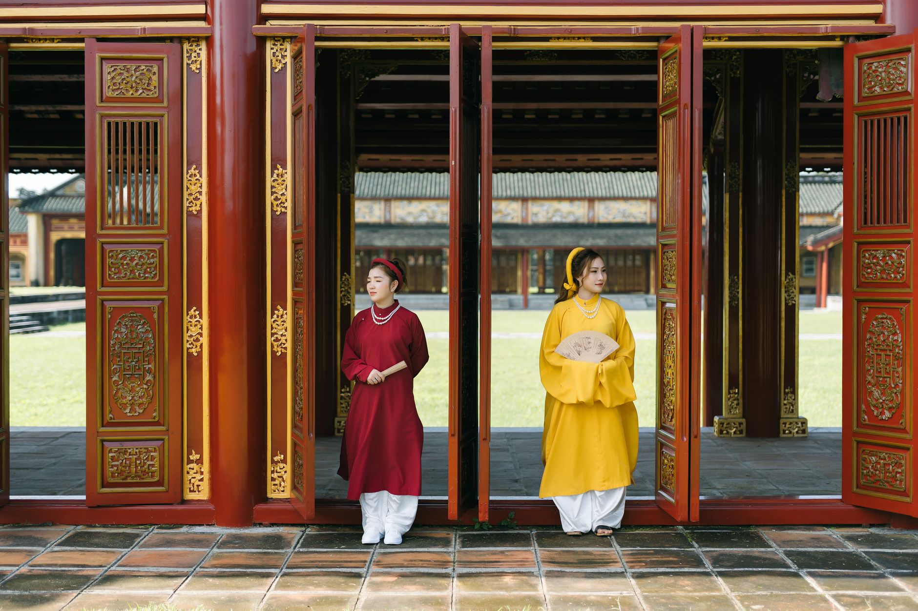 Dwie kobiety w tradycyjnych ao dai w wejściu do świątyni