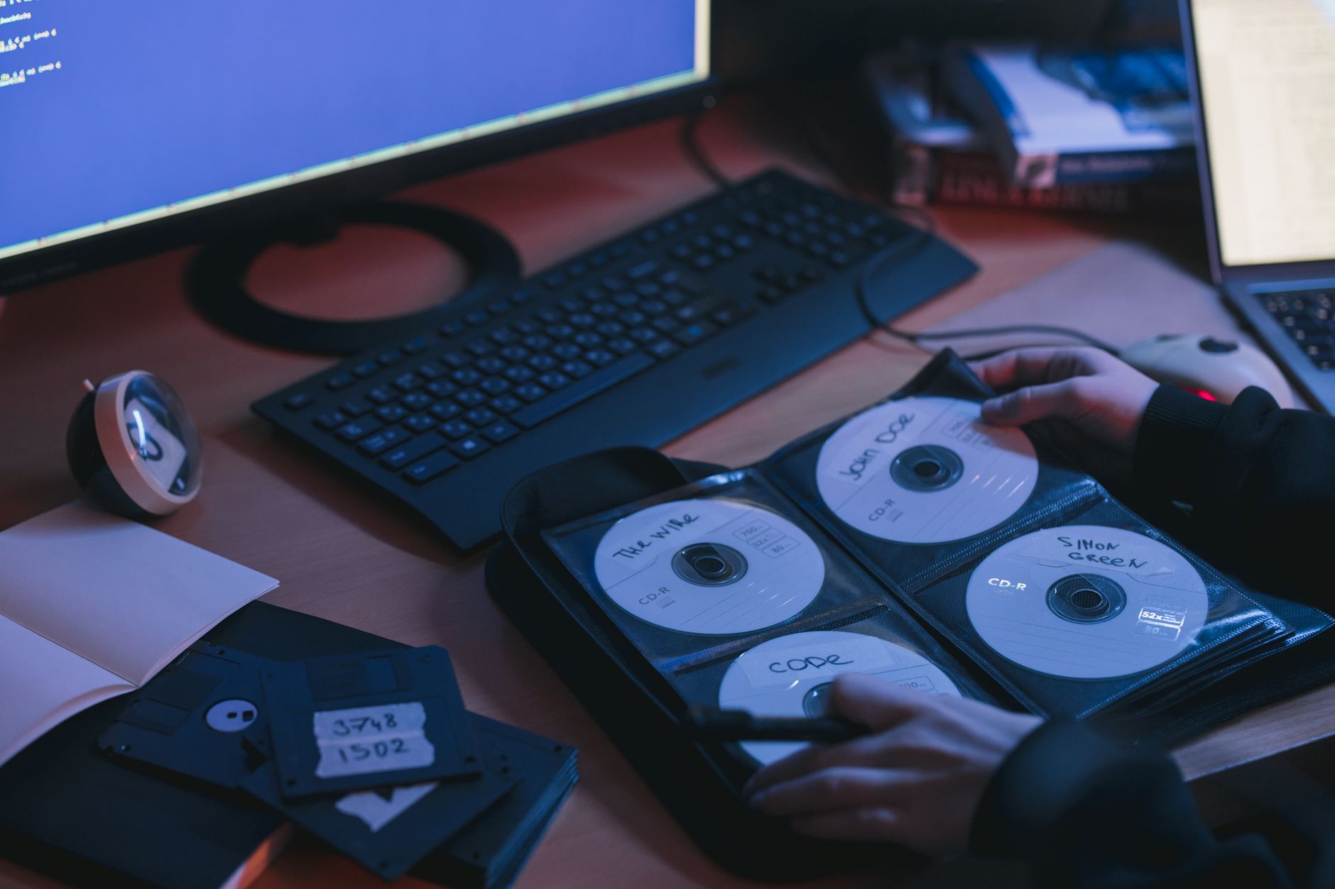 Płyty CD na biurku i dłonie pracujące w technicznym środowisku